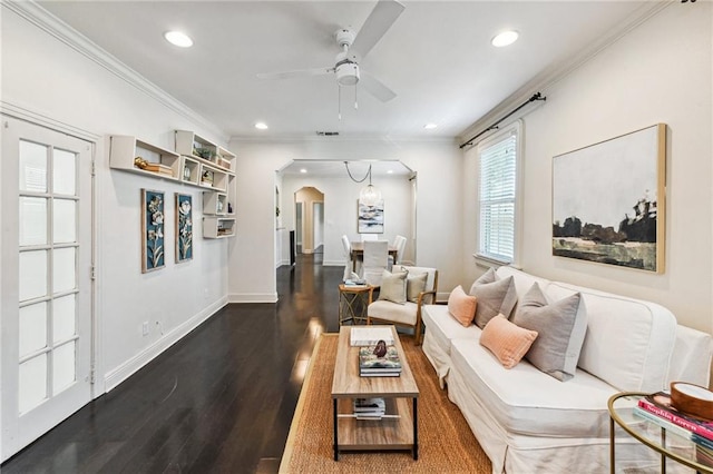 living room featuring dark hardwood / wood-style flooring, ceiling fan, and crown molding