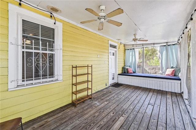 unfurnished sunroom featuring ceiling fan