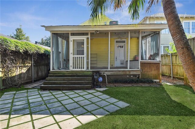 bungalow-style house featuring a sunroom and a front lawn