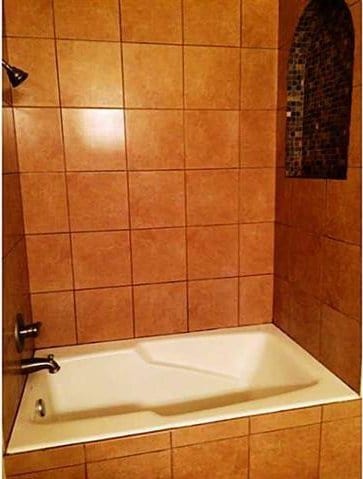 bathroom featuring tiled shower / bath