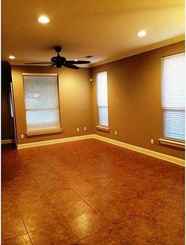 empty room with ceiling fan and crown molding