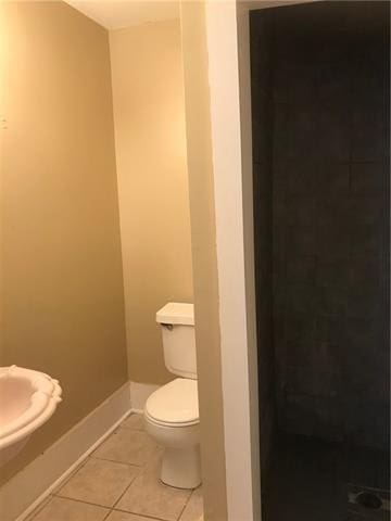 bathroom with walk in shower, tile patterned flooring, and toilet