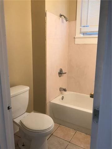 bathroom featuring tile patterned floors, washtub / shower combination, and toilet