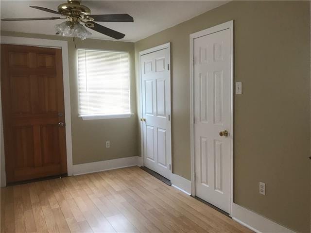 foyer entrance with light wood-type flooring and ceiling fan