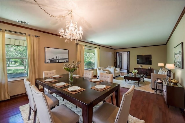 dining room featuring an inviting chandelier, dark hardwood / wood-style floors, and crown molding