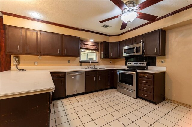 kitchen with ceiling fan, dark brown cabinetry, ornamental molding, sink, and stainless steel appliances