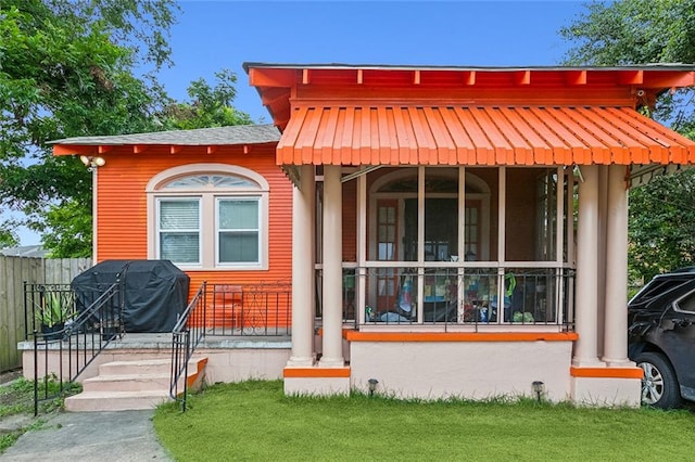 view of front of house featuring a front lawn and covered porch