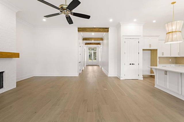 unfurnished living room featuring a brick fireplace, light hardwood / wood-style flooring, crown molding, and ceiling fan