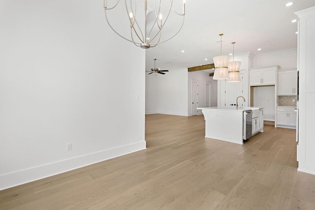 kitchen featuring light hardwood / wood-style flooring, a kitchen island with sink, backsplash, and white cabinetry