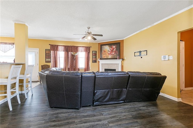 living room featuring a textured ceiling, ceiling fan, dark hardwood / wood-style floors, and crown molding