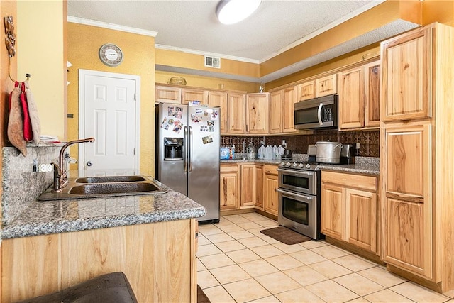 kitchen with backsplash, stainless steel appliances, dark stone counters, ornamental molding, and sink