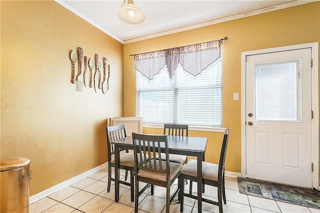 tiled dining area featuring a textured ceiling and ornamental molding