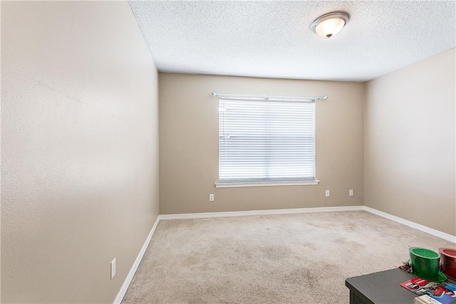 spare room with a textured ceiling and carpet flooring