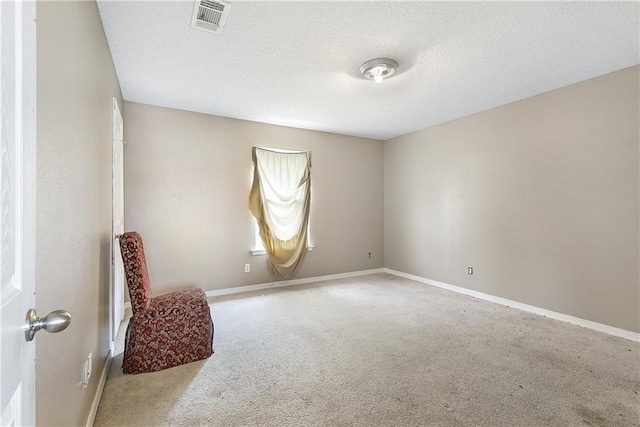 carpeted empty room featuring a textured ceiling