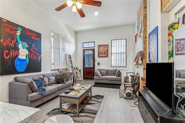 living room with light hardwood / wood-style floors and ceiling fan