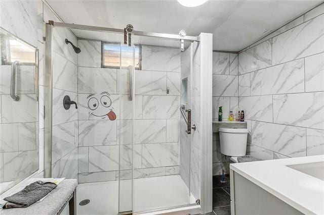 bathroom featuring vanity, tile walls, a shower with shower door, and toilet