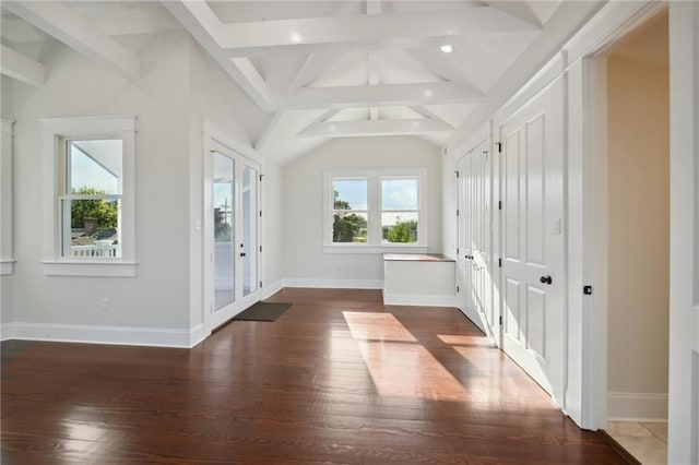 unfurnished room with vaulted ceiling with beams, wood-type flooring, and a wealth of natural light