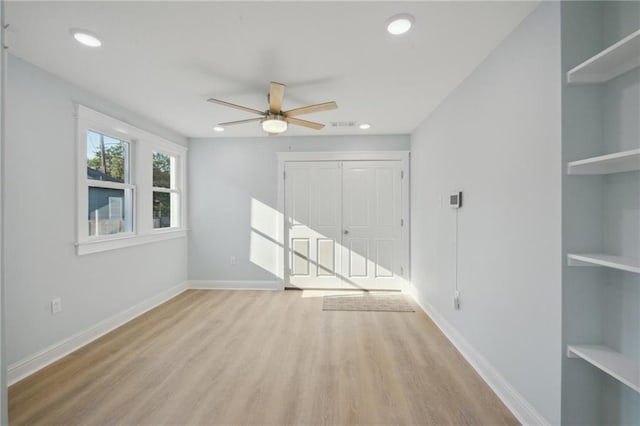 empty room with light hardwood / wood-style flooring and ceiling fan