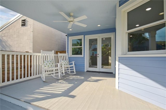 back of property with ceiling fan, a balcony, french doors, and a lawn