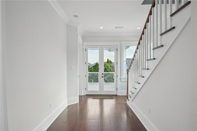 entrance foyer with ornamental molding, dark wood-type flooring, and french doors