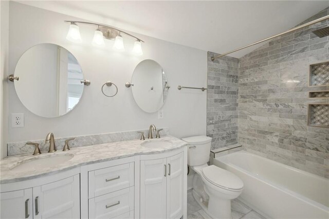 full bathroom featuring tiled shower / bath combo, vanity, and toilet