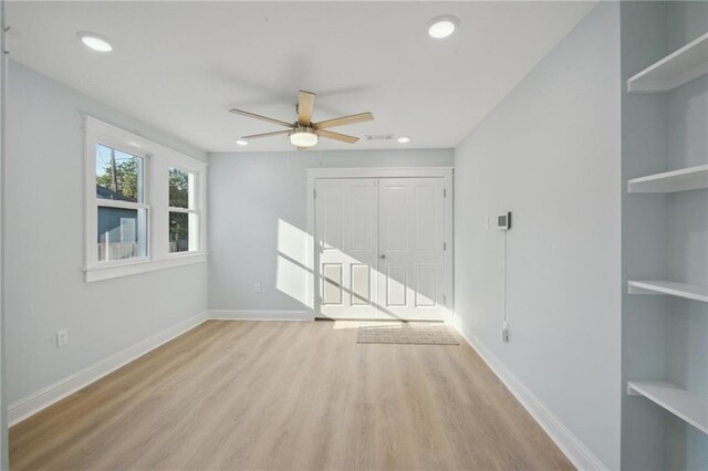 spare room featuring light wood-type flooring and ceiling fan