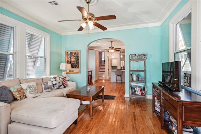 living room with ceiling fan, hardwood / wood-style flooring, and ornamental molding