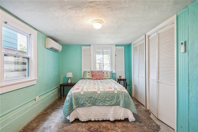 bedroom with a textured ceiling, multiple windows, and a wall mounted AC