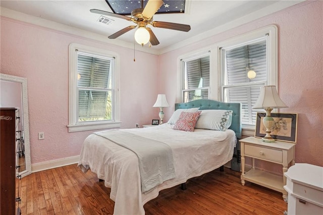 bedroom featuring light wood-type flooring, ceiling fan, multiple windows, and crown molding