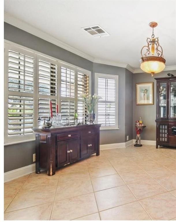 interior space with crown molding and light tile patterned floors