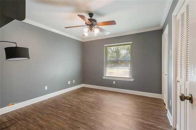 unfurnished bedroom featuring ceiling fan, ornamental molding, and dark wood-type flooring