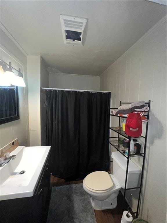 bathroom featuring a shower with curtain, crown molding, vanity, and toilet