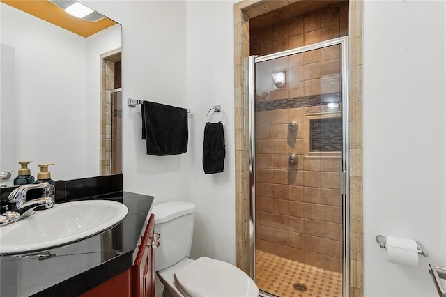 bathroom with walk in shower, vanity, and toilet