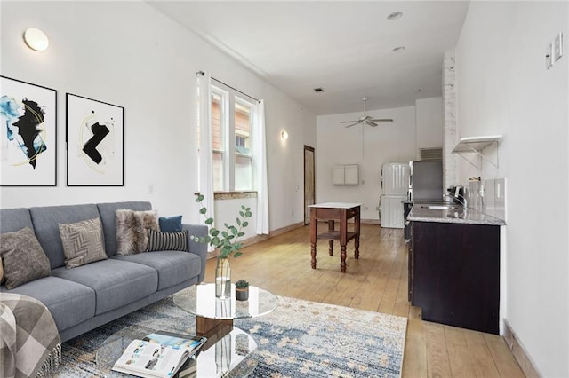 living room with ceiling fan and light wood-type flooring