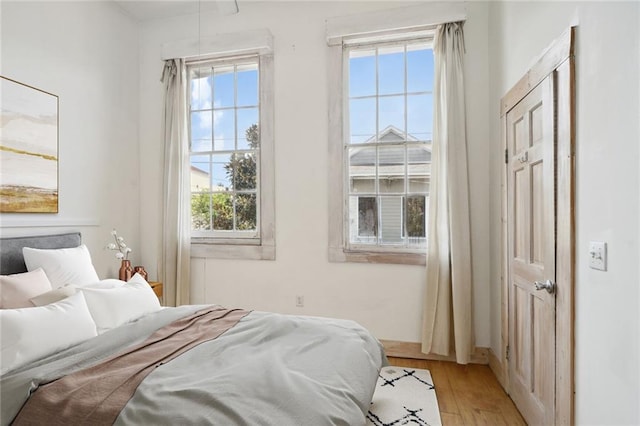 bedroom with light wood-type flooring and multiple windows