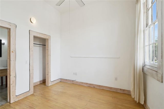 unfurnished bedroom featuring a closet, light hardwood / wood-style floors, and ceiling fan