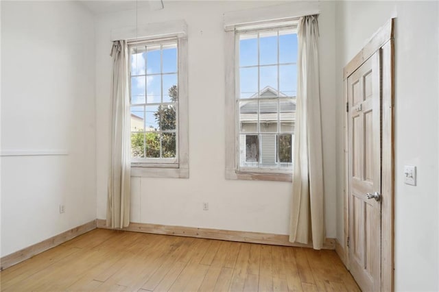 unfurnished bedroom with light wood-type flooring and multiple windows