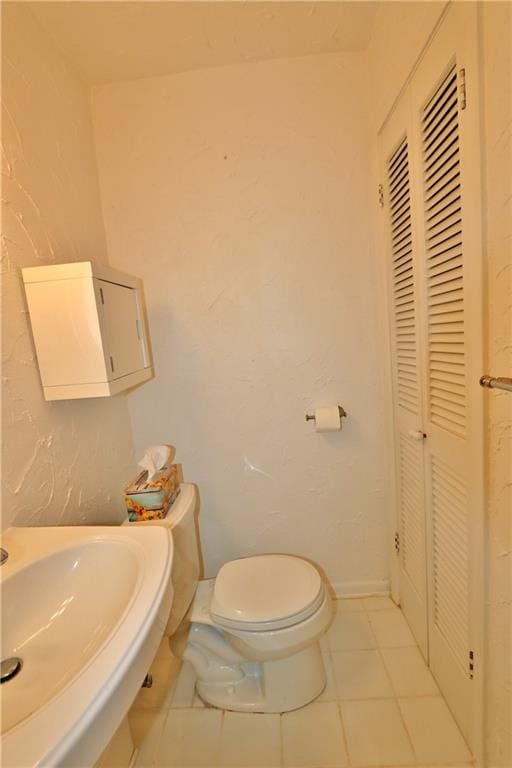 bathroom featuring tile patterned flooring, sink, and toilet