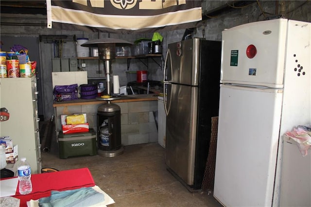 interior space with concrete flooring, stainless steel fridge, and white fridge