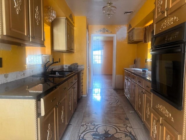 kitchen with sink, light tile patterned floors, and oven