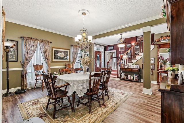 dining room featuring a chandelier, crown molding, a textured ceiling, and hardwood / wood-style floors