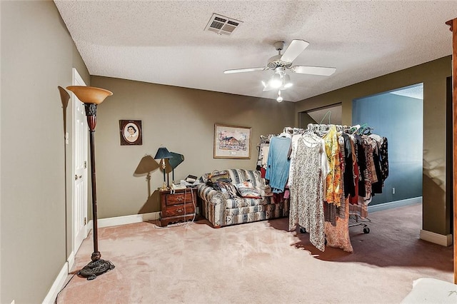 carpeted bedroom with ceiling fan and a textured ceiling