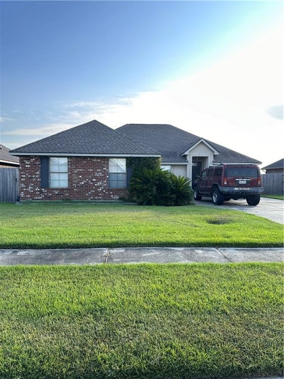 single story home featuring a front lawn