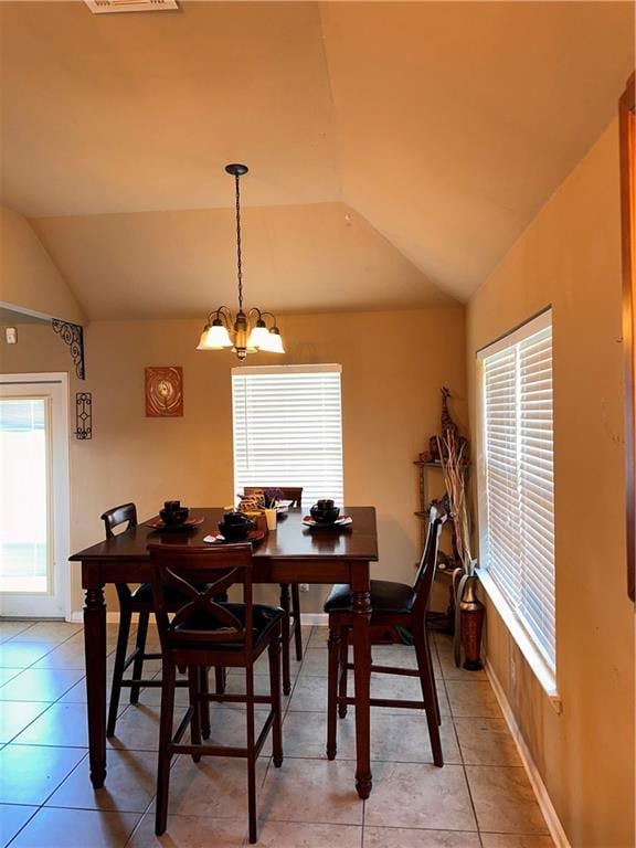 tiled dining space with a notable chandelier and lofted ceiling