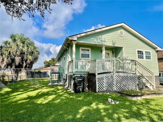 back of house with a lawn and a wooden deck