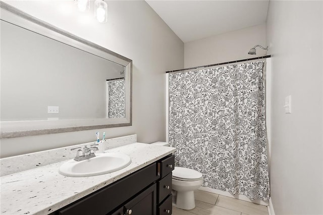 bathroom featuring walk in shower, vanity, toilet, and tile patterned floors