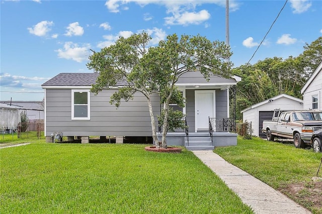 bungalow-style house featuring a garage, an outdoor structure, and a front lawn