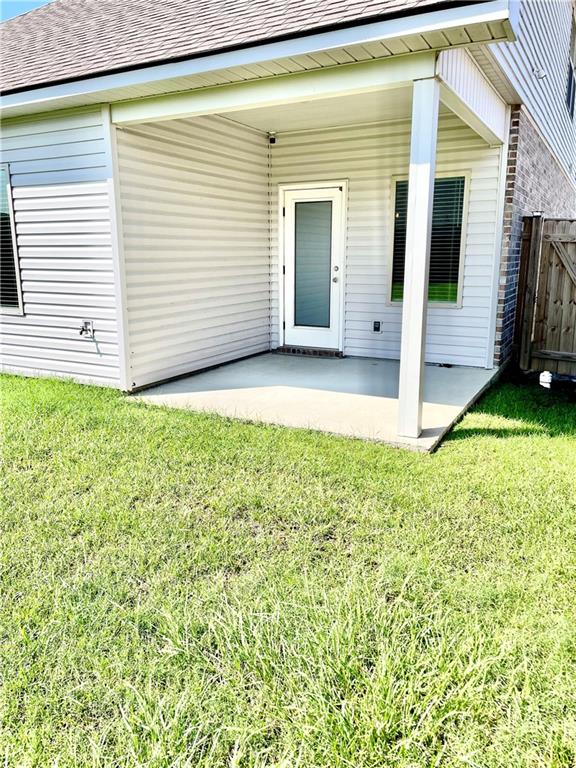 property entrance featuring a yard and a patio