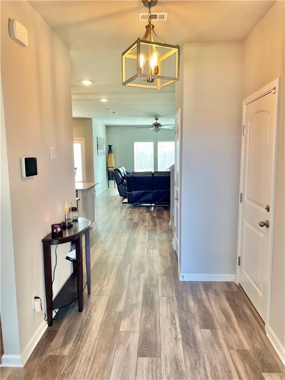 hall featuring hardwood / wood-style floors and a notable chandelier