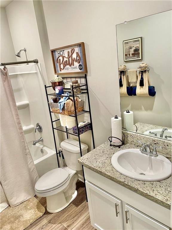 full bathroom with vanity, hardwood / wood-style floors, shower / bathtub combination with curtain, and toilet